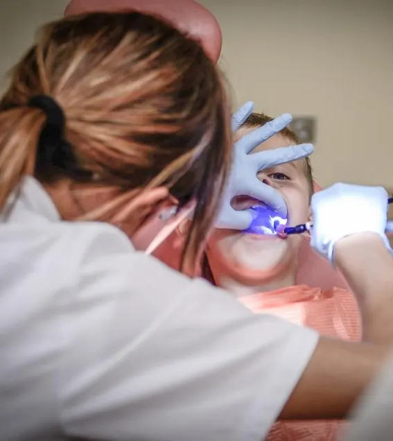 Dentista atendendo um paciente na cadeira, foto de exemplo